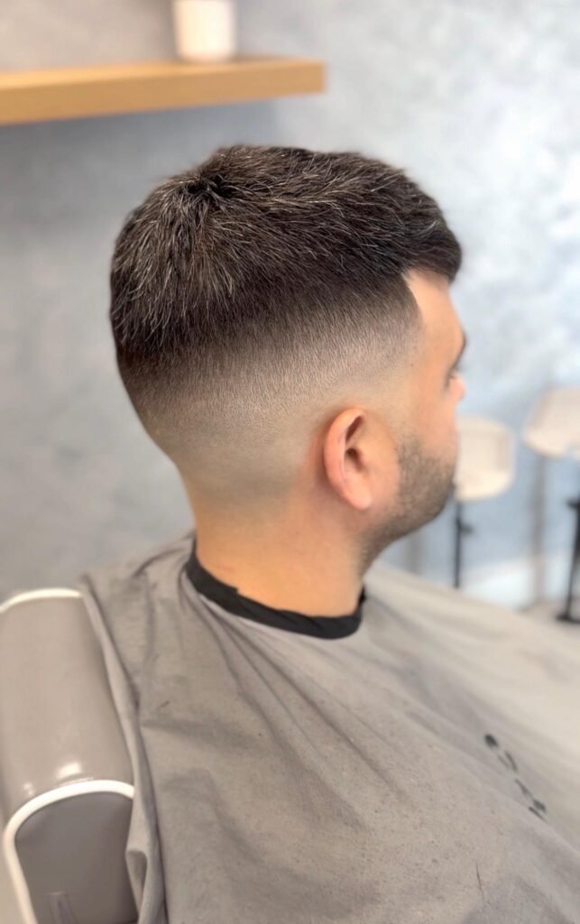Men's hair system with a Caesar cut and skin fade, back side view