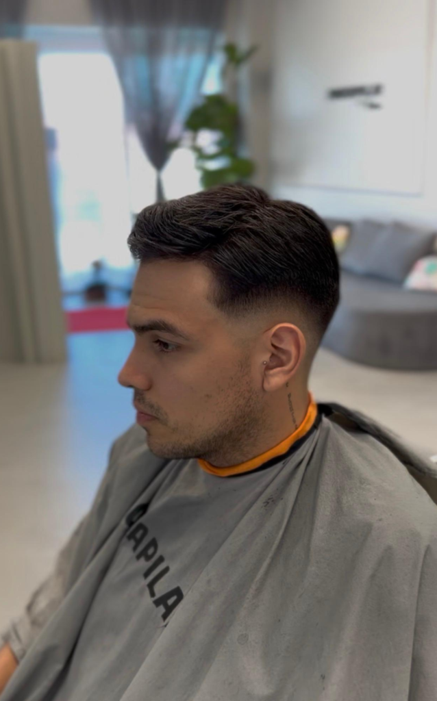 Men's hair system with a textured top and mid fade, side view